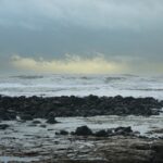 Littoral rocheux battu par les vagues sous un ciel de tempête