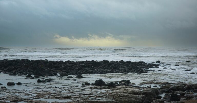 Littoral rocheux battu par les vagues sous un ciel de tempête