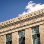 Close-up of the Department of Agriculture building facade under a clear blue sky.