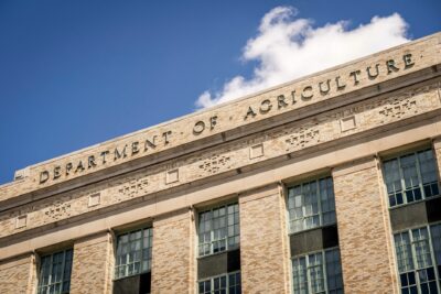 Close-up of the Department of Agriculture building facade under a clear blue sky.